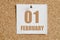 february 01. 01th day of the month, calendar date.White calendar sheet attached to brown cork board.Winter month, day of
