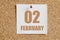 february 02. 02th day of the month, calendar date.White calendar sheet attached to brown cork board.Winter month, day of
