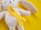 February, 15 Still life teddy hare with a gold ribbon on yellow background. Childhood Cancer Awareness day concept