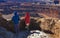 FEBRUARY 16, 2019 - CANYONLANDS NATIONAL PARK, MOAB, UTAH - Man and woman ponder Panoramic View of Dead Horse State Park,