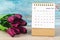 The February 2023 Desk calendar for 2023 year with flower on wooden background