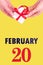 February 20th. Festive Vertical Calendar With Hands Holding White Gift Box With Red Ribbon And Calendar Date