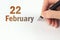 February 22nd. Day 22 of month, Calendar date. The hand holds a black pen and writes the calendar date. Winter month, day of the