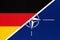 Federal Republic of Germany national fabric flag from textile vs North Atlantic Treaty Organization sign. NATO