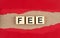FEE word on wooden cubes on red torn paper , financial concept background