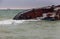 Feed of a sinking tanker ship in a sea water with a raid vessel on background