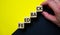 Feedback symbol. Concept word `feedback` on cubes on a beautiful black and yellow background. Male hand. Business and feedback