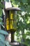 Feeder for birds, made from an empty glass flask. Use of household rubbish in decorative, and practical purposes in