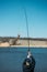Feeder fishing. Carp Fishing Steel Basket Bait Feeder on rod close up. Male fisherman fishing at sun day on the lake