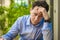 Feeling exhausted. Frustrated young man keeping eyes closed while sitting at his working place in office