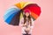 Feeling good. Girl having fun walking wireless headphones under colorful umbrella. Fall leisure. Music always with me