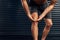 Feeling the pain in his knee. Studio shot of an unrecognizable holding his knee against a dark background.