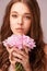 Feeling whimsical. Beautiful young woman holding a bunch of pink flowers against a pink background.