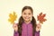 Feelings of comfort and nostalgia we experience in autumn are hard to express. Kid girl hold fallen maple leaves. Happy