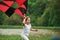 It feels awesome. Positive female child running with red and black colored kite in hands outdoors