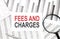 FEES AND CHARGES text on document with pen,graph and magnifier,calculator