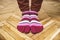 Feet in amusing multi-colored striped socks stand on an old parquet