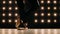 Feet of ballerina in pointe shoes is dancing ballet in the dark studio.