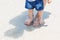 Feet Barefoot of Dad and son on sand at the beautiful beach