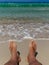 Feet on the beach enjoying the relax and the amazing view of paradisiac sea