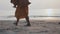 Feet of buddhist monk walks on the beach with urn in hands at morning