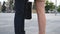 Feet of businessman in black shoes and businesswoman on high-heels standing at city street. Business couple meeting in