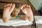 Feet close up. Boy sitting on upper berth in train and plays on the tablet