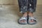 Feet of a construction worker in old dirty clothes and shoes