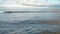 Feet of Couple in Shoes Sitting on Pier and Looking at Sea Waves in Autumn Day