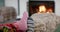 Feet of couple in socks relaxing at home in front of open fire, slow motion