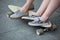 Feet couple of teenagers in sneakers on longboard