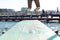 feet of a diver ready to dive off a blue diving board pocking out over the waves in a bay and protected sea bath in Geelong,