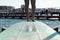 feet of a diver ready to dive off a blue diving board pocking out over the waves in a bay and protected sea bath in Geelong,