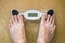 Feet on electric scales on wooden background. Diet concept