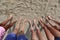 Feet of a family of five on the sandy beach in summer