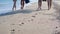 Feet of four active young people walking along the coast