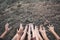 Feet and hand of children praying for the rain on cracked dry ground