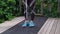 Feet and legs of muscular man starting workout with a heavy jump rope