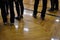 Feet and legs of people waiting in a school gym