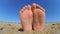 Feet legs strewn sprinkled with sand sanded on the sandy beach.