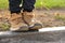 Feet of a little boy in brown nubuck shoes in autumn in a city park. Comfortable waterproof demi-season shoes