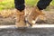 Feet of a little boy in brown nubuck shoes in autumn in a city park. Comfortable waterproof demi-season shoes