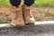 Feet of a little boy in brown nubuck shoes in autumn in a city park. Comfortable waterproof demi-season shoes