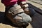 Feet of little girl in beige Velcro boots standing on wooden floor