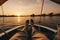 Feet of a man relaxing on a boat on the river at sunset, Crop unrecognizable barefooted male traveler sitting on edge of boat