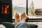 Feet at modern fireplace and window with view on mountains. Woman barefoot relaxing in cozy home