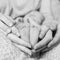 Feet of Newborn baby feet in parent hands, black and white photo. Birth, happiness and happy family concept