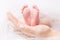 Feet of Newborn Baby, Mother Holding New Born Kid Legs on Hand