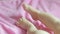 Feet of a newborn baby on a pink terry bedspread close-up.