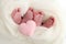 Feet newborn twins Two pairs of baby feet in a white knitted blanket. Pink heart